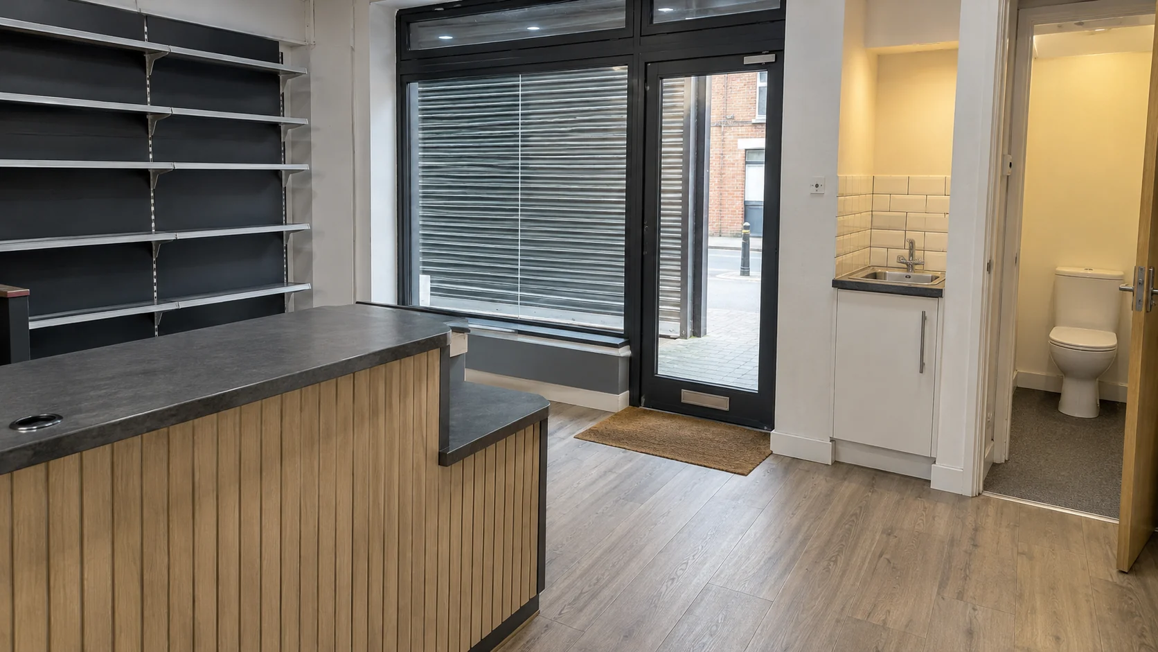 Small retail unit interior showing counter, shelving, entrance, kitchenette and WC